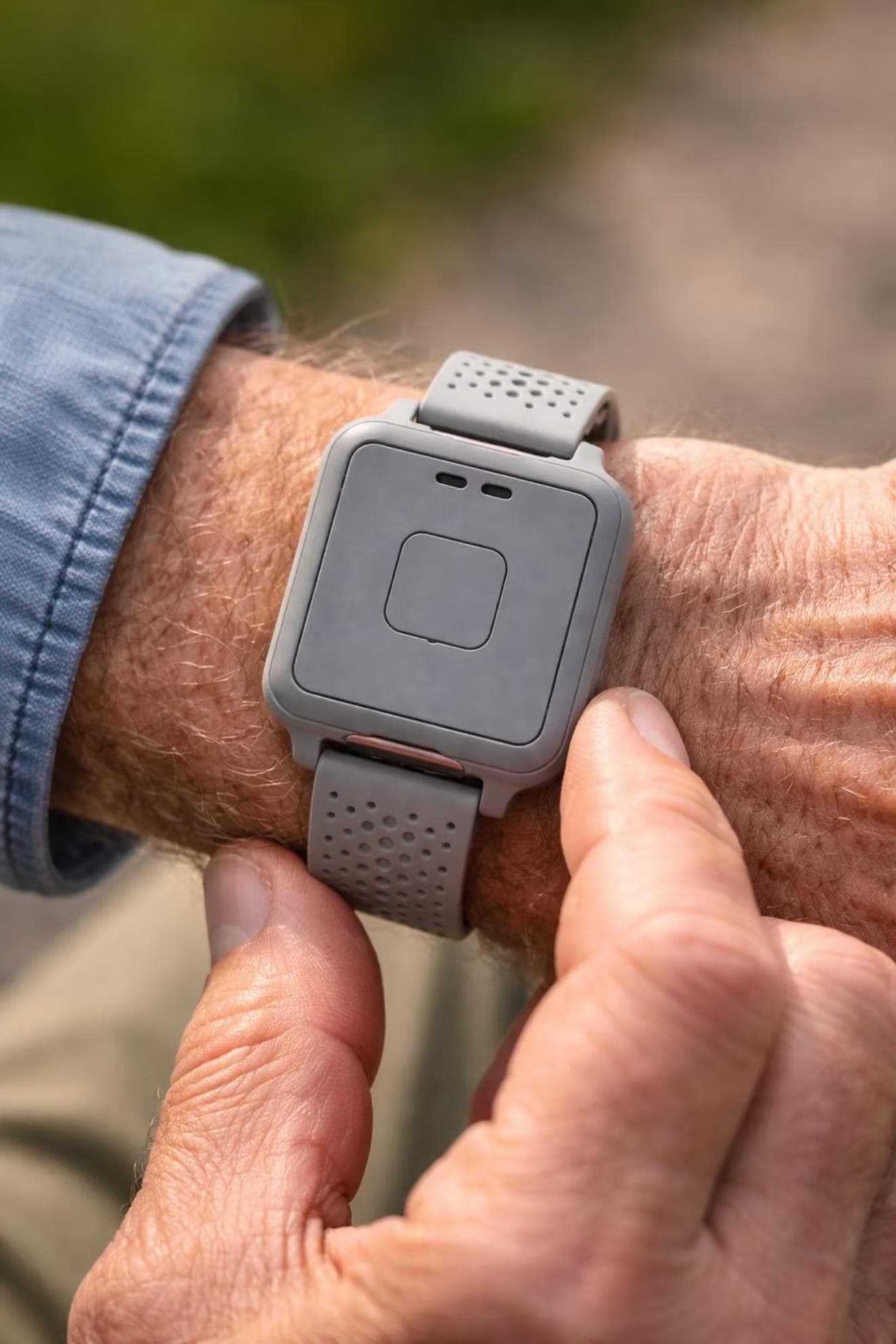 GCARE bracelet worn outdoors on an older adult's wrist